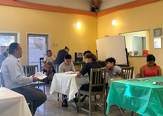 Image of middle school students at tables and an instructor