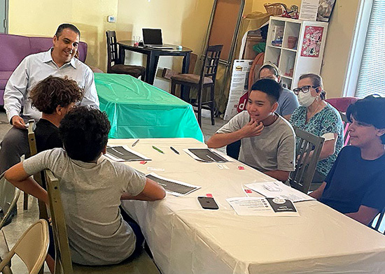 Image of middle school students at tables and an instructor at Highland Village